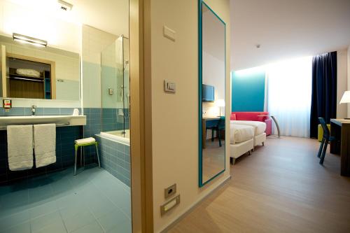 a hotel room with a bathroom with a tub and a bed at Hotel Mercure Venezia-Marghera in Marghera