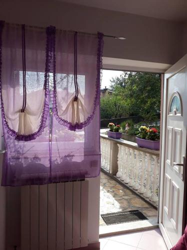 an open door to a balcony with a purple curtain at Studio apartman"Mirjana", Podhum 368 in Podhum