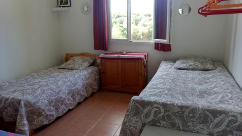 deux lits dans une petite pièce avec une fenêtre dans l'établissement Bio verdon, à Régusse