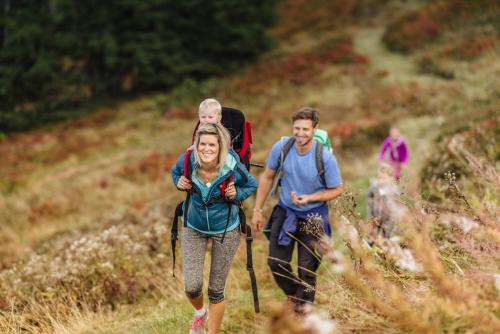 a group of people walking down a trail at Aparthotel DAS Hochkönig in Ramsau am Dachstein