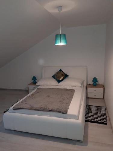 ein Schlafzimmer mit einem weißen Bett und einem blauen Licht in der Unterkunft Apartman Mohenski in Zagreb