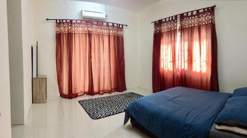 Schlafzimmer mit roten Vorhängen, einem Bett und einem Fenster in der Unterkunft Lily Homestay @ Kangar, Perlis in Kangar