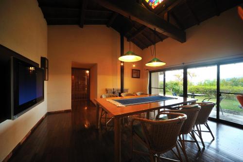 a dining room with a table and chairs and a television at Meigetsuso in Kaminoyama