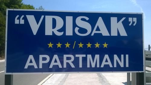 un panneau bleu qui dit vaticanariarma avec des étoiles sur une route dans l'établissement Apartments Vrisak, à Brist