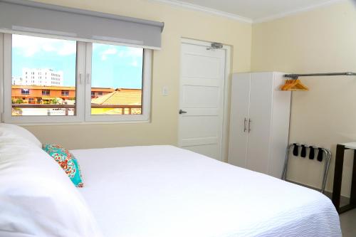 een slaapkamer met een wit bed en een raam bij Casa Alessandra 1bdr in Palm-Eagle Beach