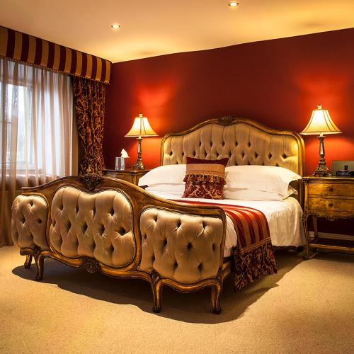 a bedroom with a large bed with a tufted headboard at Grassington House in Grassington