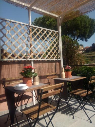 two tables and chairs on a patio with a fence at UP&B Rooms Catania in Mascalucia