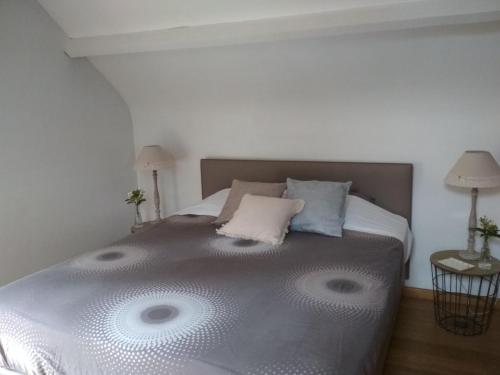 een slaapkamer met een groot bed met 2 kussens bij Kericouette et Délices in Le Vieux-Bourg