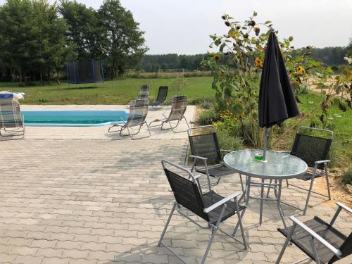een terras met stoelen, een tafel en een parasol bij s'Schnoganeschd in Nemesvid