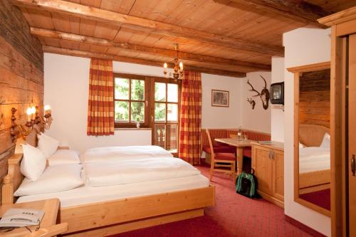 a bedroom with a large bed and a table at Hotel Kirchenwirt in Kirchberg in Tirol