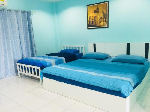 2 camas en una habitación con paredes azules en Best Rent a Room, en Nai Yang Beach