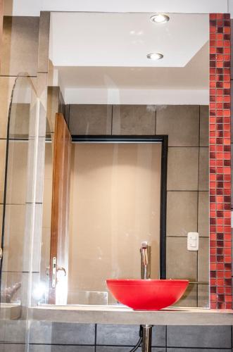 a bathroom with a red sink and a mirror at Los Perales in San Salvador de Jujuy