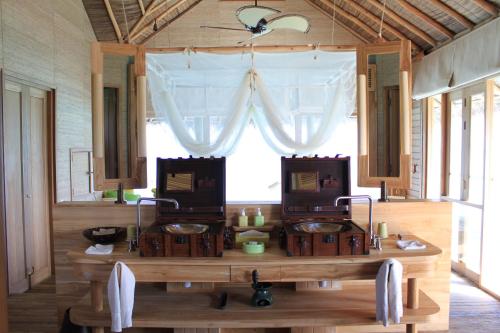 a room with two sinks in front of a window at Six Senses Laamu in Laamu