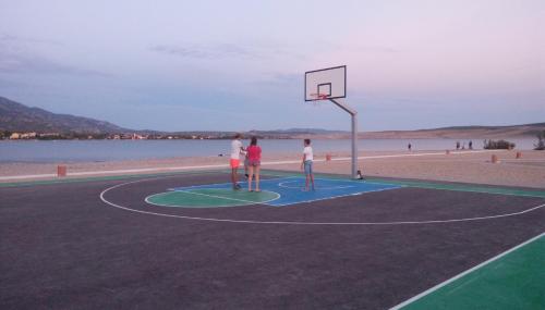 two people playing basketball on a basketball court on the beach at Apartmani Spomenka in Seline