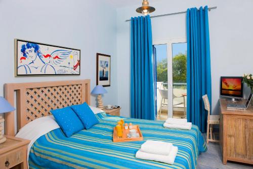 a blue bedroom with a bed with a tray on it at Alesahne Beach Hotel in Kamari