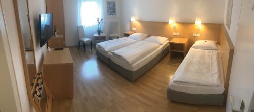 a hotel room with two beds and a television at Weinhaus Selmigkeit in Bingen am Rhein