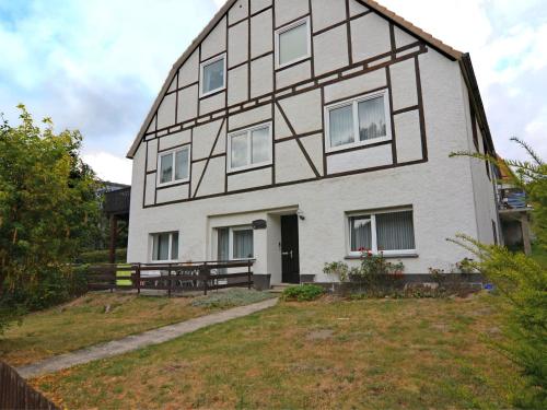 Biały dom z czarno-białym budynkiem w obiekcie Apartment in Sauerland with terrace w mieście Helminghausen