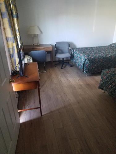a hotel room with a desk and a bed and a desk at Neva Jean Motel in Marshfield