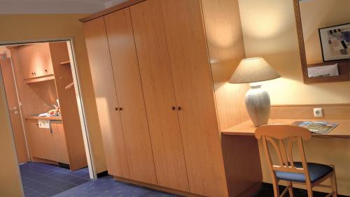 a room with a desk with a lamp and a chair at Best Western Aparthotel Birnbachhöhe in Bad Birnbach