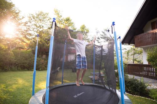 a young boy jumping on a trampoline at Chalet Ana Bohinj in Bohinj