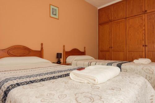 フロンテーラにあるApartamentos Las Casitasのベッドルーム1室(白い毛布が敷かれたベッド3台付)
