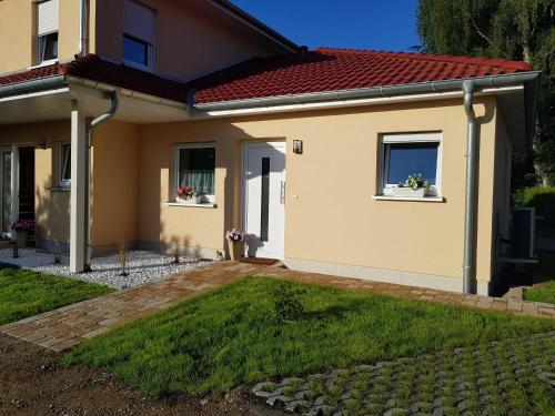 ein Haus mit zwei Fenstern und einem Hof in der Unterkunft Ferienwohnung Inselglück in Ahlbeck