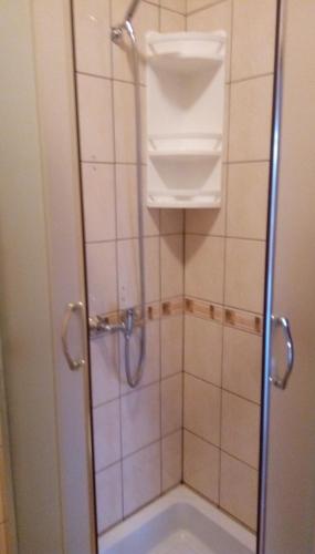 a shower with a glass door in a bathroom at Apartmani Spomenka in Seline