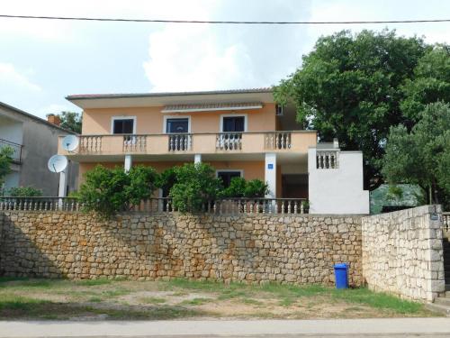 a house behind a stone wall at Apartmani Spomenka in Seline