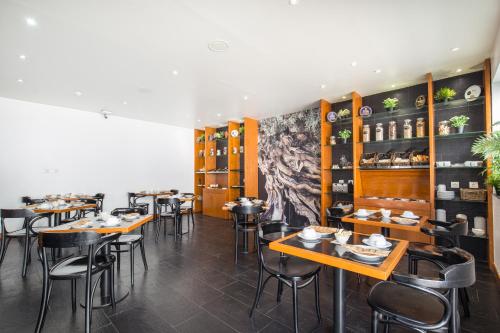 a restaurant with tables and chairs in a room at Residencial Mar e Sol in Costa da Caparica