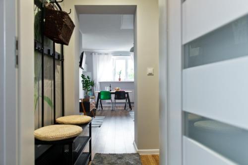 a hallway with stools and a dining room with a table at Old Town Apartments in Szczecin