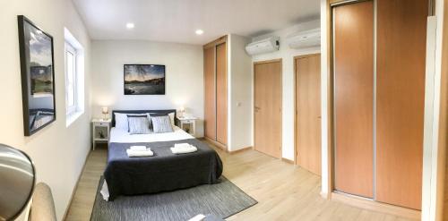 ein Schlafzimmer mit einem Bett, auf dem zwei Handtücher liegen in der Unterkunft Porto Luxury Apartments in Vila Nova de Gaia