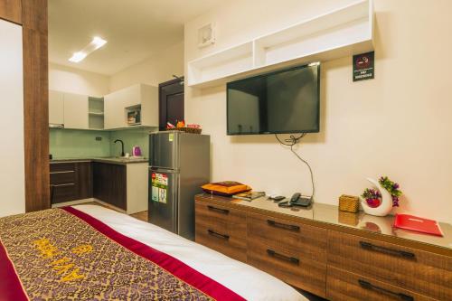 a kitchen with a tv on the wall of a room at AVA Hotel & Apartment in Danang
