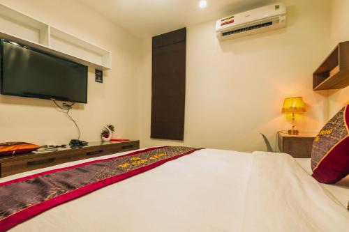 a bedroom with a bed with a flat screen tv at AVA Hotel & Apartment in Danang