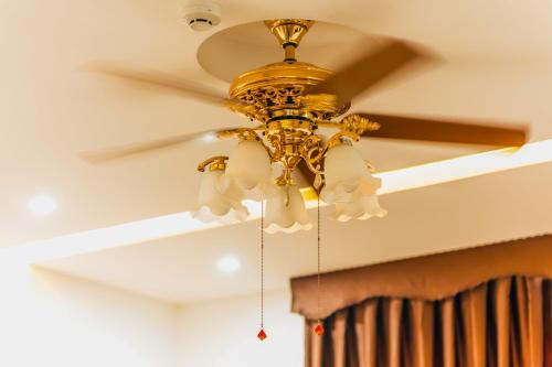 a gold ceiling fan hanging from a ceiling at AVA Hotel & Apartment in Danang