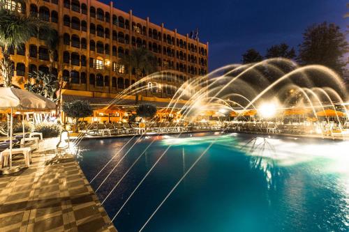 a pool with water fountains in front of a building at El Andalous Lounge & Spa Hotel in Marrakech