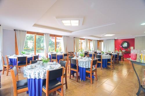 un comedor con mesas y sillas con asientos azules en Pousada Chamamé, en Bonito