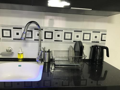 a kitchen counter with a sink and a sink at Cozy modern apartment near the sea in city center in Netanya