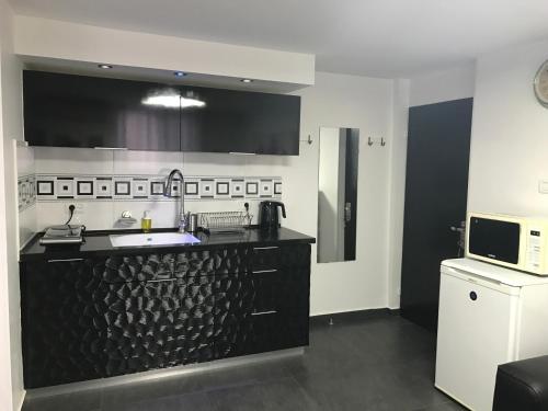 a kitchen with a black counter and a microwave at Cozy modern apartment near the sea in city center in Netanya