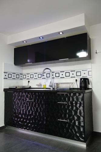 a kitchen with a black counter and a sink at Cozy modern apartment near the sea in city center in Netanya