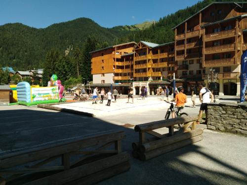 a group of people walking around a park with buildings at Le Thabor in Valfréjus