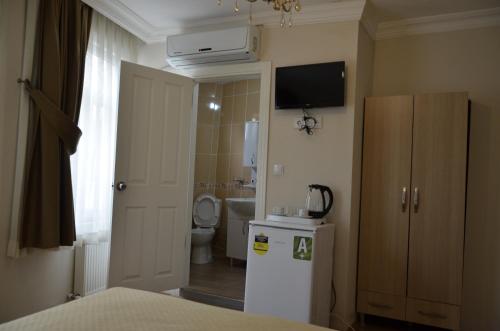a small bathroom with a refrigerator and a toilet at Piya Hostel in Istanbul
