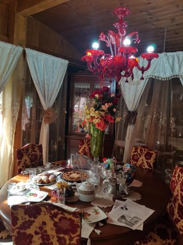 einen Esstisch mit einem Kronleuchter und Blumen darauf in der Unterkunft B&B Marilena affittacamere in Rocca Imperiale