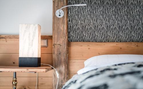 a bedroom with a bed and a lamp on a table at Sporthotel Exclusive in San Vigilio Di Marebbe