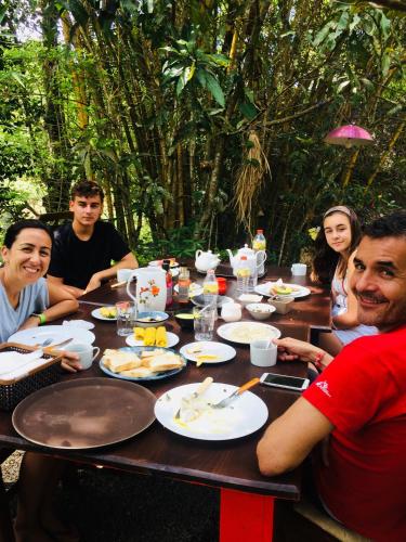 a group of people sitting around a table with food at Moksha eco villa Ella in Ella