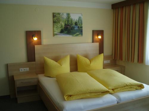 a bedroom with a bed with yellow pillows at Haus Wiesenblick in Längenfeld