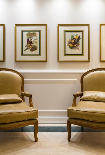 two chairs in a room with paintings on the wall at Villa do Vale Boutique Hotel in Blumenau