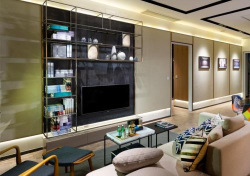 a living room with a couch and a tv at Expressionz Suites By iHost Global in Kuala Lumpur