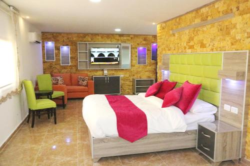 a bedroom with a bed with red and green pillows at Petra Sella Hotel in Wadi Musa