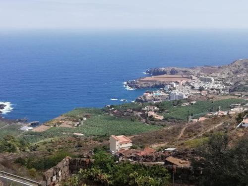 a town on a hill next to the ocean at Mirador Playa San Marcos in Icod de los Vinos