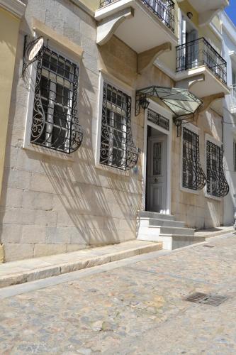 a building with windows and stairs and a door at Ariadni Rooms & Apartments in Ermoupoli